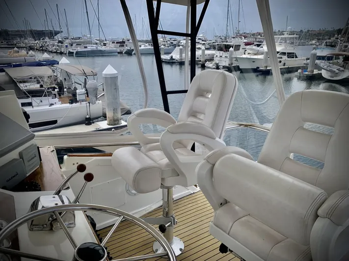  Yacht Photos Pics 1984 Egg Harbor 48 Flybridge Cruiser interior with marina view, featuring white captain chairs.