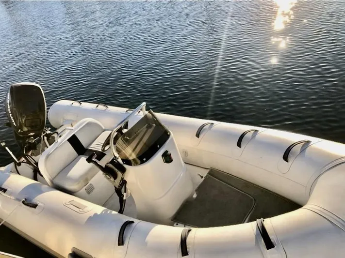  Yacht Photos Pics Inflatable boat on water, featuring a motor and seating, under sunlight reflections.