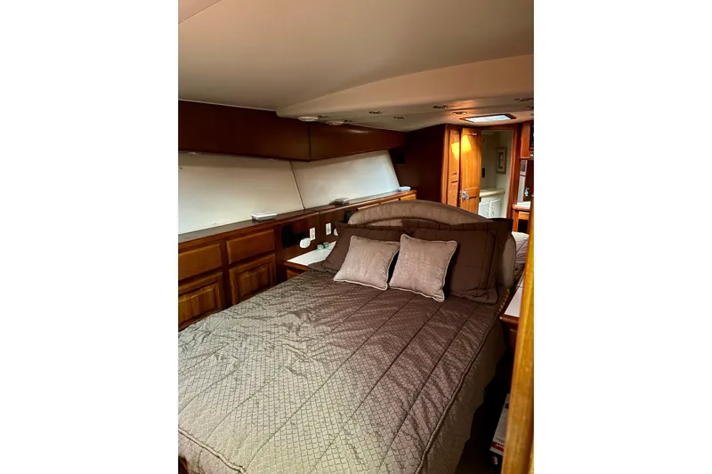 All In Yacht Photos Pics Cozy bedroom interior of 1993 Viking 50 Convertible yacht with wooden cabinetry.