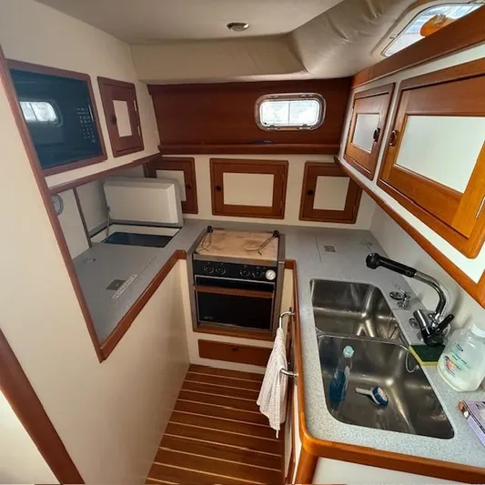  Yacht Photos Pics 1997 Little Harbor WhisperJet 46 yacht kitchen with wood cabinetry, dual sink, and compact appliances.