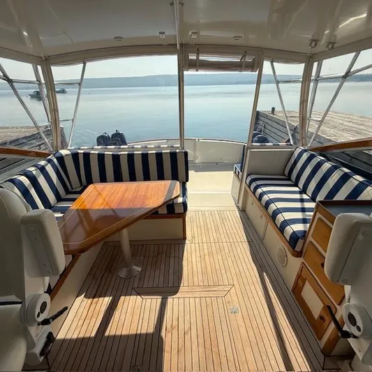  Yacht Photos Pics Interior of 1997 Little Harbor WhisperJet 46 with striped seating and wooden table.