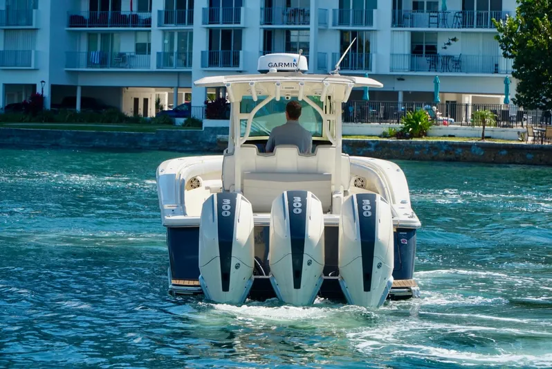 Af1 Yacht Photos Pics 2019 Scout 355 LXF boat with four engines cruising on water near buildings.