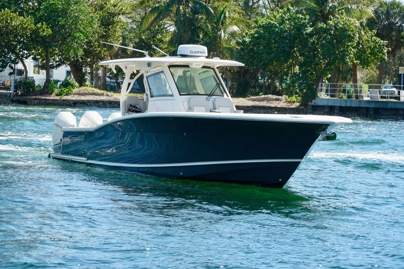 Af1 Yacht Photos Pics 2019 Scout 355 LXF boat cruising on clear blue water near lush greenery.