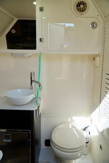 Af1 Yacht Photos Pics 2019 Scout 355 LXF boat bathroom with sink, toilet, and storage cabinets.