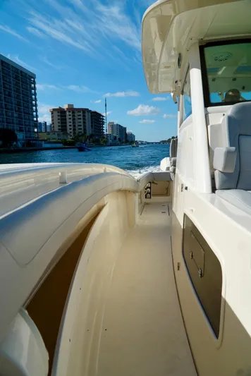 Af1 Yacht Photos Pics 2019 Scout 355 LXF boat cruising on a sunny day, cityscape in background.