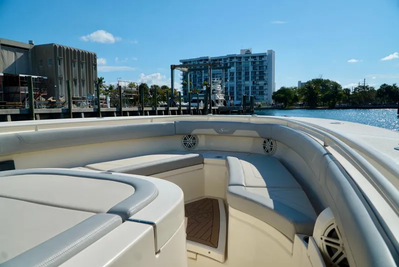 Af1 Yacht Photos Pics 2019 Scout 355 LXF boat interior with cushioned seating, dockside view, and waterfront building.