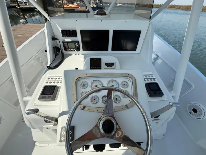  Yacht Photos Pics Helm of 2003 Strike 35 Cuddy boat with steering wheel and navigation instruments.