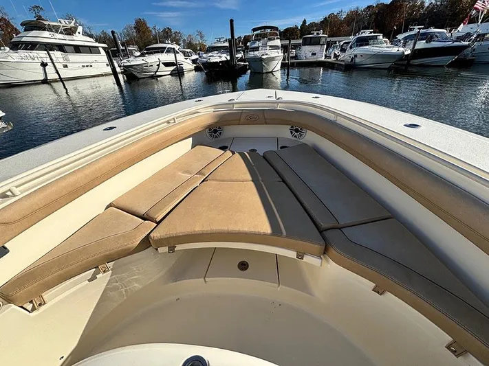  Yacht Photos Pics 2016 Scout 350 LXF boat with cushioned seating, docked in a marina.