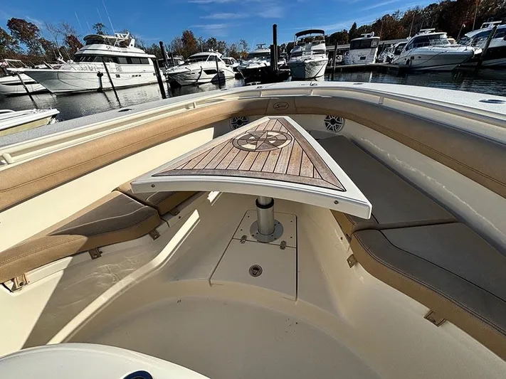  Yacht Photos Pics 2016 Scout 350 LXF boat interior with wooden table and seating, docked at marina.
