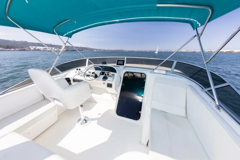 Adventures Await Yacht Photos Pics 2004 Meridian 490 Pilothouse yacht interior with helm, white seating, and ocean view.