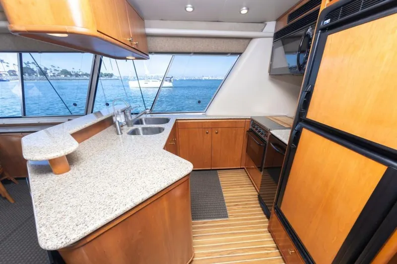 Adventures Await Yacht Photos Pics Luxurious 2004 Meridian 490 Pilothouse yacht kitchen with ocean view, featuring modern appliances.