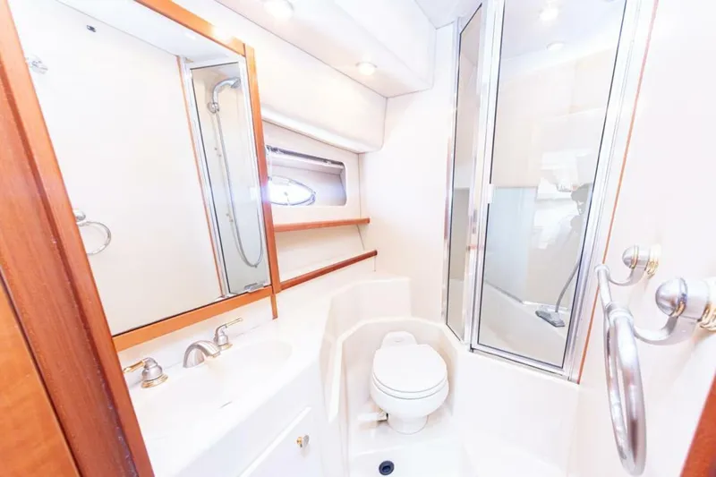 Adventures Await Yacht Photos Pics Bathroom interior of 2004 Meridian 490 Pilothouse yacht, featuring shower and toilet.