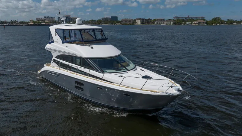 Gail’s Storm IV Yacht Photos Pics 2015 Meridian 441 Sedan cruising on a sunny day, with cityscape in the background.