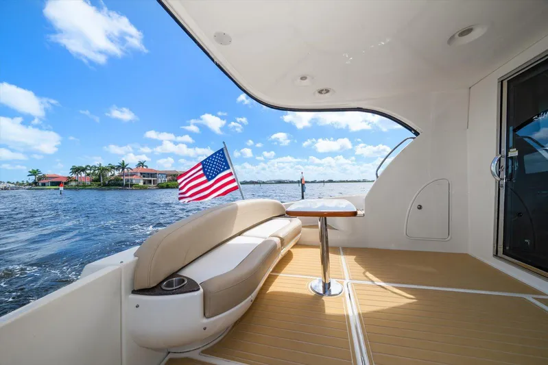 Gail’s Storm IV Yacht Photos Pics 2015 Meridian 441 Sedan yacht deck with American flag, scenic waterfront view.