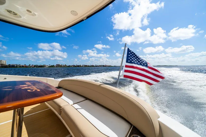 Gail’s Storm IV Yacht Photos Pics 2015 Meridian 441 Sedan yacht cruising with American flag, sunny day, blue sky, and ocean view.