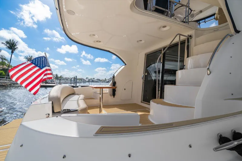 Gail’s Storm IV Yacht Photos Pics 2015 Meridian 441 Sedan yacht deck with American flag, sunny waterfront view.