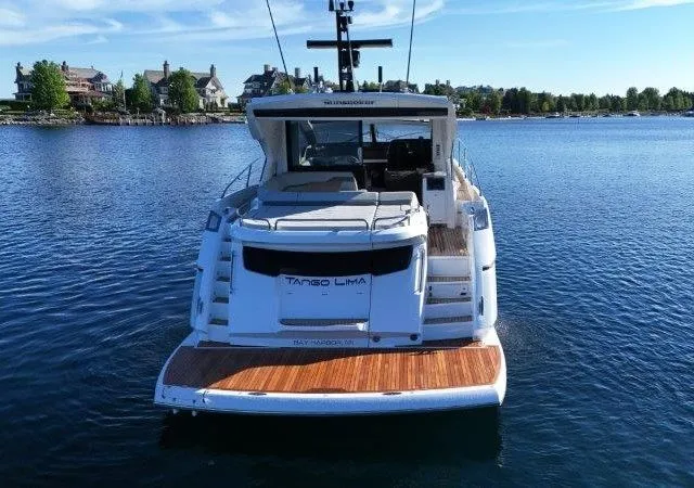 Tango Lima Yacht Photos Pics 2022 Sunseeker 60 Predator EVO yacht on calm water, rear view.