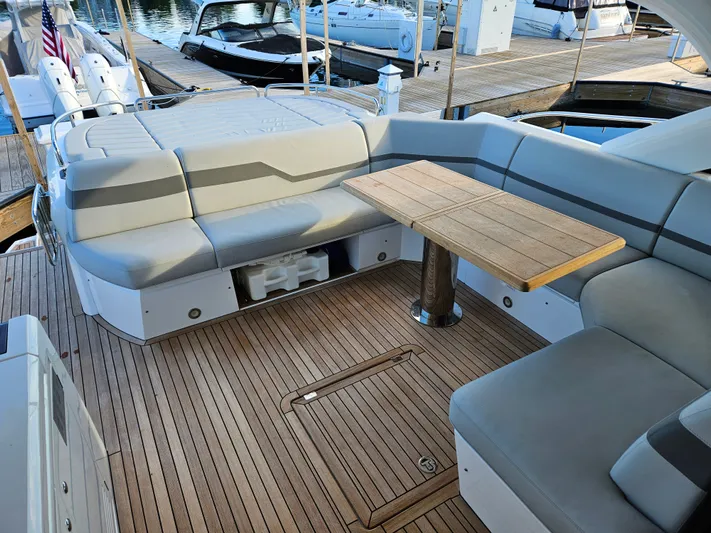 Tango Lima Yacht Photos Pics Luxurious Sunseeker 60 Predator EVO 2022 yacht deck with seating and wooden table.