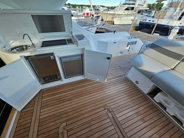 Tango Lima Yacht Photos Pics Sunseeker 60 Predator EVO 2022 yacht deck with seating, kitchenette, and open storage.