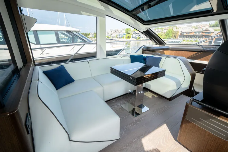 Tango Lima Yacht Photos Pics Luxurious interior of 2022 Sunseeker 60 Predator EVO yacht with white seating and modern table.