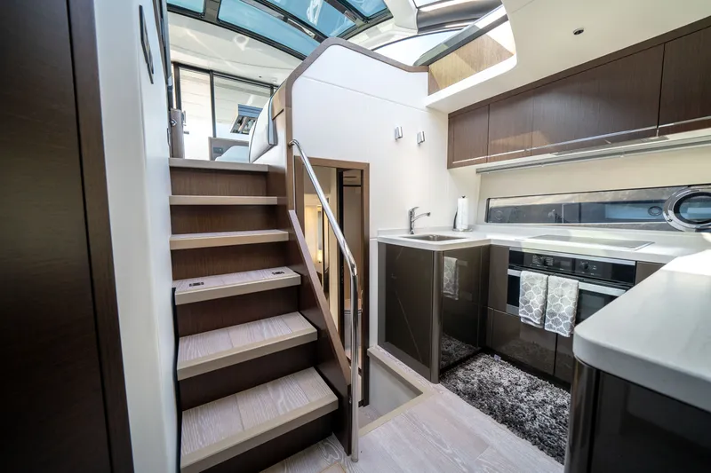 Tango Lima Yacht Photos Pics Luxurious interior of 2022 Sunseeker 60 Predator EVO yacht, featuring modern kitchen and staircase.