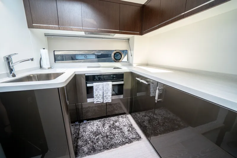Tango Lima Yacht Photos Pics Modern kitchen interior on 2022 Sunseeker 60 Predator EVO yacht, featuring sleek cabinetry and appliances.