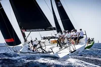 Sailing team on TP52 yacht racing in open sea, 2007 model.