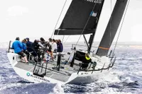 Sailing team on TP52 yacht "Blue Carbon" racing in open sea, 2007 model.