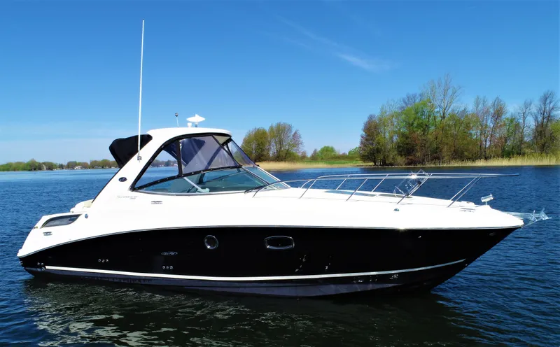  Yacht Photos Pics 2010 Sea Ray 310 Sundancer boat on a calm lake with trees in the background.