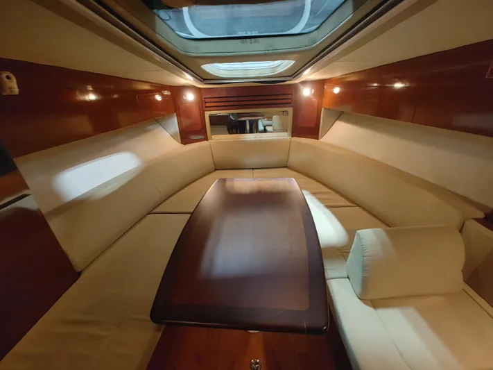  Yacht Photos Pics Luxurious interior of 2010 Sea Ray 310 Sundancer yacht with plush seating and wooden table.