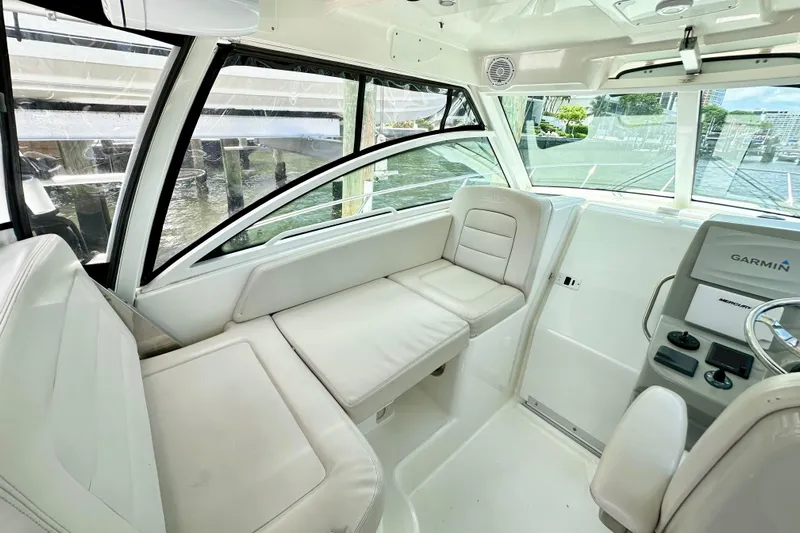 Extra Vagancia Yacht Photos Pics 2015 Boston Whaler 315 Conquest interior with white seating and Garmin navigation system.