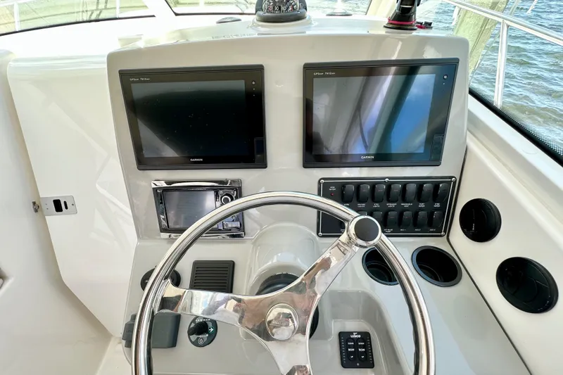 Extra Vagancia Yacht Photos Pics Control panel of 2015 Boston Whaler 315 Conquest with dual Garmin displays and steering wheel.