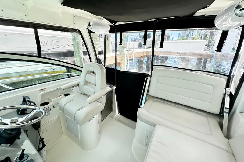 Extra Vagancia Yacht Photos Pics Interior of 2015 Boston Whaler 315 Conquest boat with white seating and steering wheel.