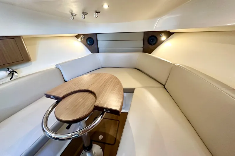 Extra Vagancia Yacht Photos Pics 2015 Boston Whaler 315 Conquest cabin with beige seating and wooden table.