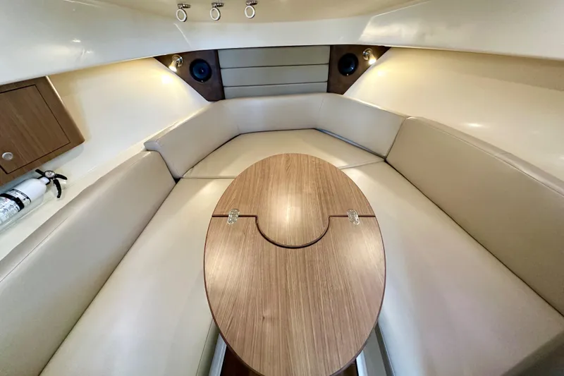 Extra Vagancia Yacht Photos Pics Interior of 2015 Boston Whaler 315 Conquest, featuring a cozy seating area and wooden table.