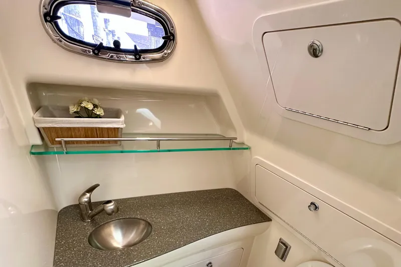 Extra Vagancia Yacht Photos Pics 2015 Boston Whaler 315 Conquest bathroom with sink, porthole, and storage compartments.