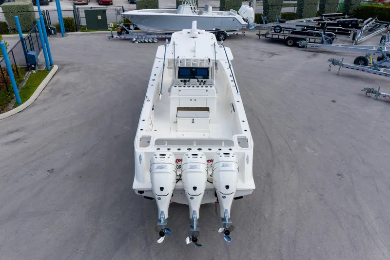 Seavee Yacht Photos Pics 2022 SeaVee 370Z boat with triple outboard engines, parked on a concrete lot.