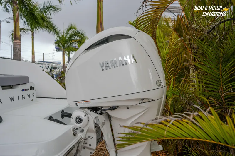  Yacht Photos Pics 2026 Four Winns H9 OB boat with Yamaha outboard motor, surrounded by tropical plants.