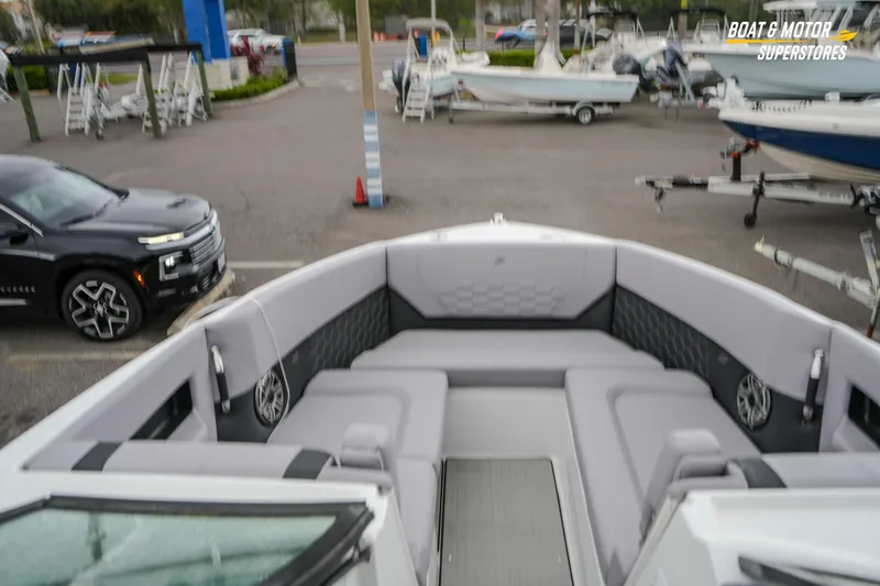  Yacht Photos Pics 2026 Four Winns H9 OB boat interior with gray seating, parked in a dealership lot.