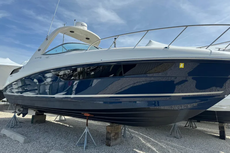  Yacht Photos Pics 2015 Sea Ray 310 Sundancer boat on stands, blue and white exterior, clear sky background.