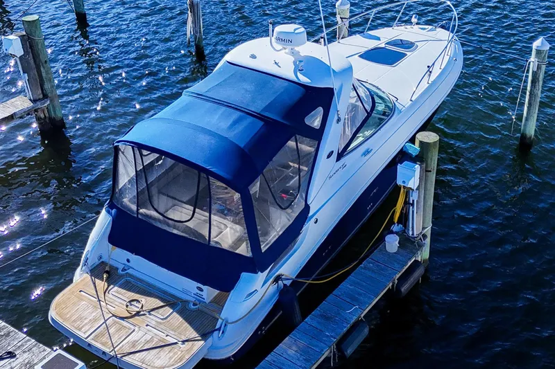  Yacht Photos Pics 2015 Sea Ray 310 Sundancer docked, featuring blue canopy and sleek design.