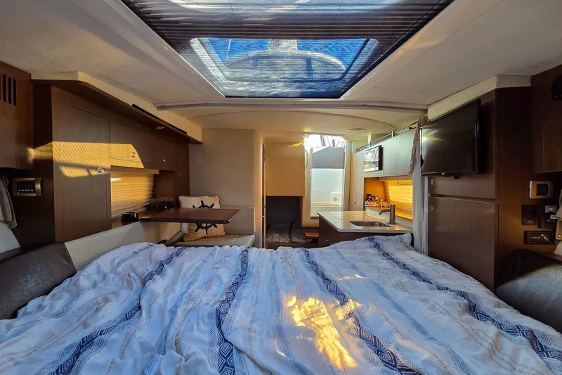  Yacht Photos Pics Interior of 2015 Sea Ray 310 Sundancer yacht with bed, skylight, and kitchenette.