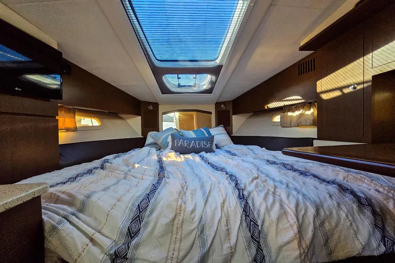  Yacht Photos Pics Luxurious interior cabin of 2015 Sea Ray 310 Sundancer yacht with skylight and cozy bedding.