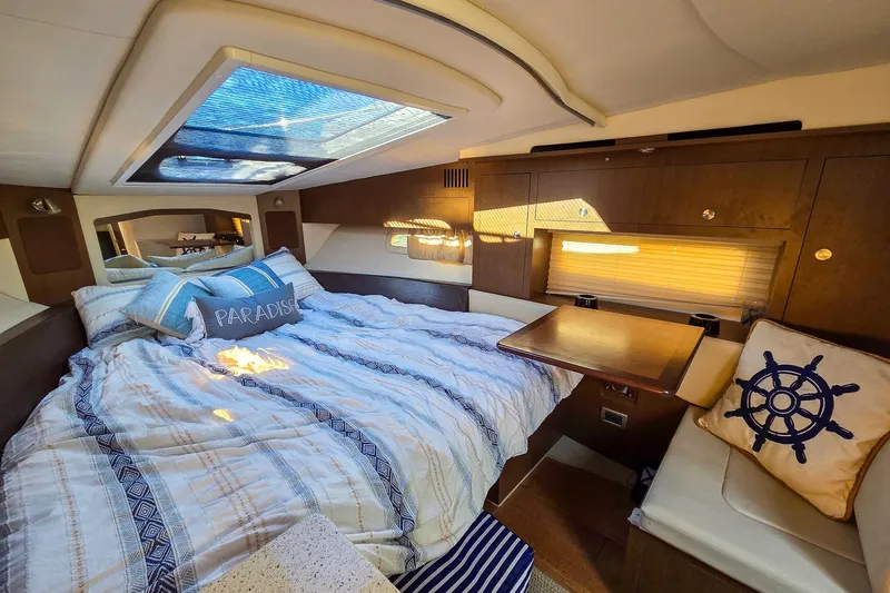  Yacht Photos Pics Luxurious interior of 2015 Sea Ray 310 Sundancer with cozy bed and nautical decor.