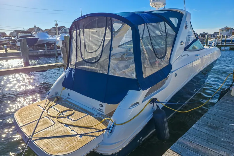  Yacht Photos Pics 2015 Sea Ray 310 Sundancer docked, featuring blue canopy and wooden deck.
