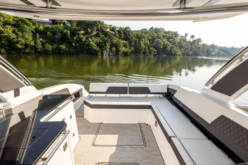  Yacht Photos Pics Luxurious 2023 Cobalt R33 boat interior with scenic lake view and lush greenery.