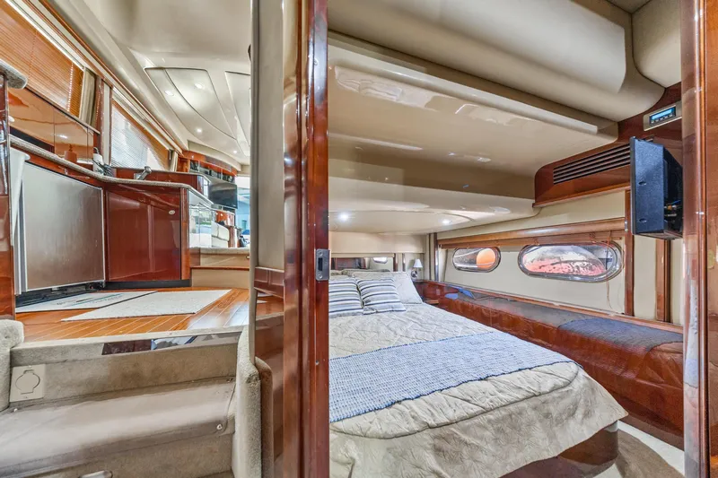 The Blue Fish Yacht Photos Pics Luxurious interior of 2007 Sea Ray 52 Sedan Bridge yacht, featuring a cozy bedroom.