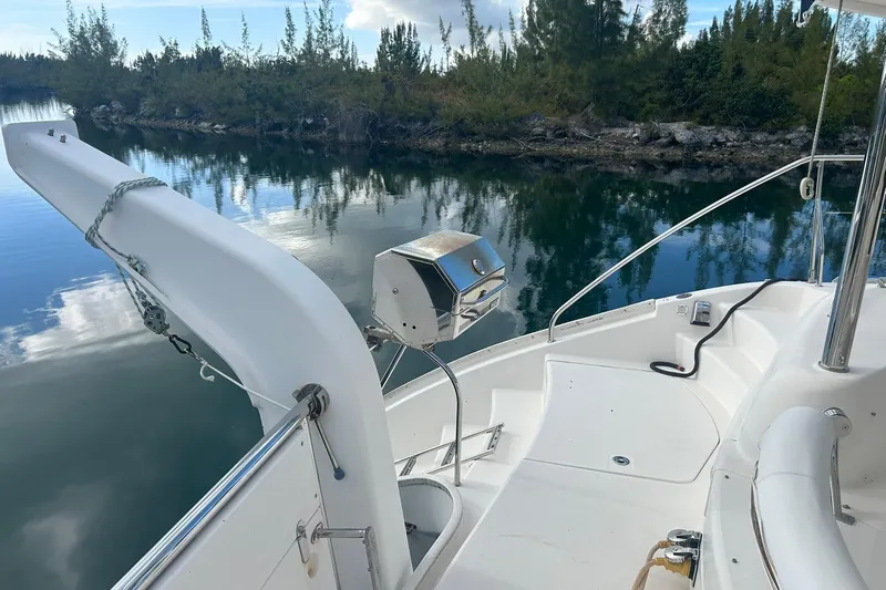 Shearwater Yacht Photos Pics 2011 Leopard 47 Powercat deck with grill, docked by serene water and lush greenery.