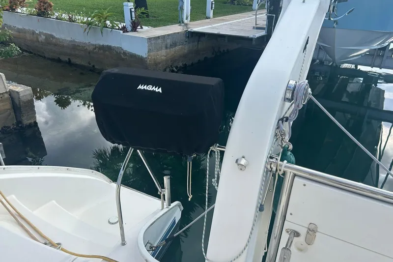 Shearwater Yacht Photos Pics Leopard 47 Powercat 2011 with Magma grill cover, docked near lush greenery.