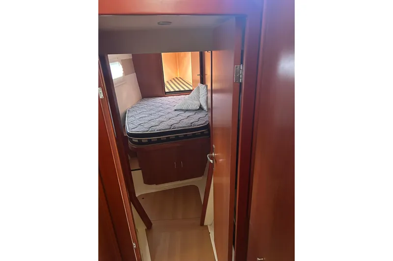 Shearwater Yacht Photos Pics 2011 Leopard 47 Powercat cabin interior with bed and wooden finish.